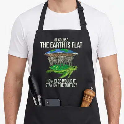Flat astrophysicist apron - Flat earth quote above three elephants standing on a green turtle with distressed grey text — shown on a black cotton canvas apron against a white background