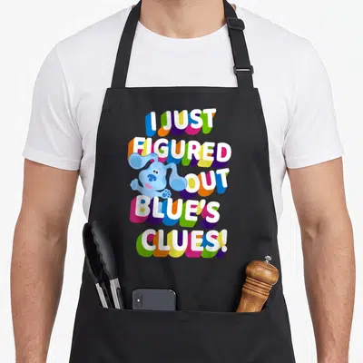 Blue colorful apron - I Just Figured Out Blue's Clues stacked text with blue cartoon dog and colorful shadows — shown on a black cotton canvas apron against a white background