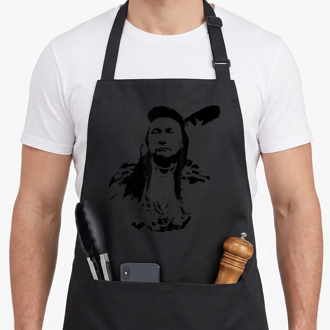 History heritage aprons - Black line art portrait of Chief Joseph with feather and necklaces — shown on a black cotton canvas apron against a white background