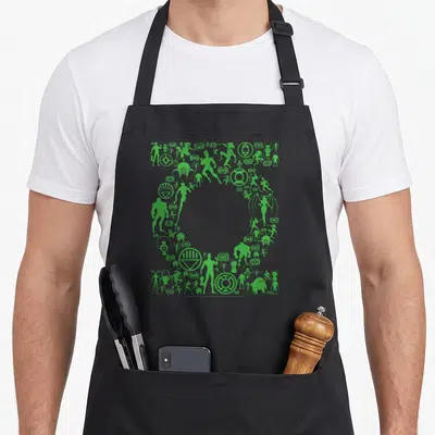 Icon novelty apron - Green silhouettes of characters and symbols forming a large circular void in a square layout — shown on a black cotton canvas apron against a white background