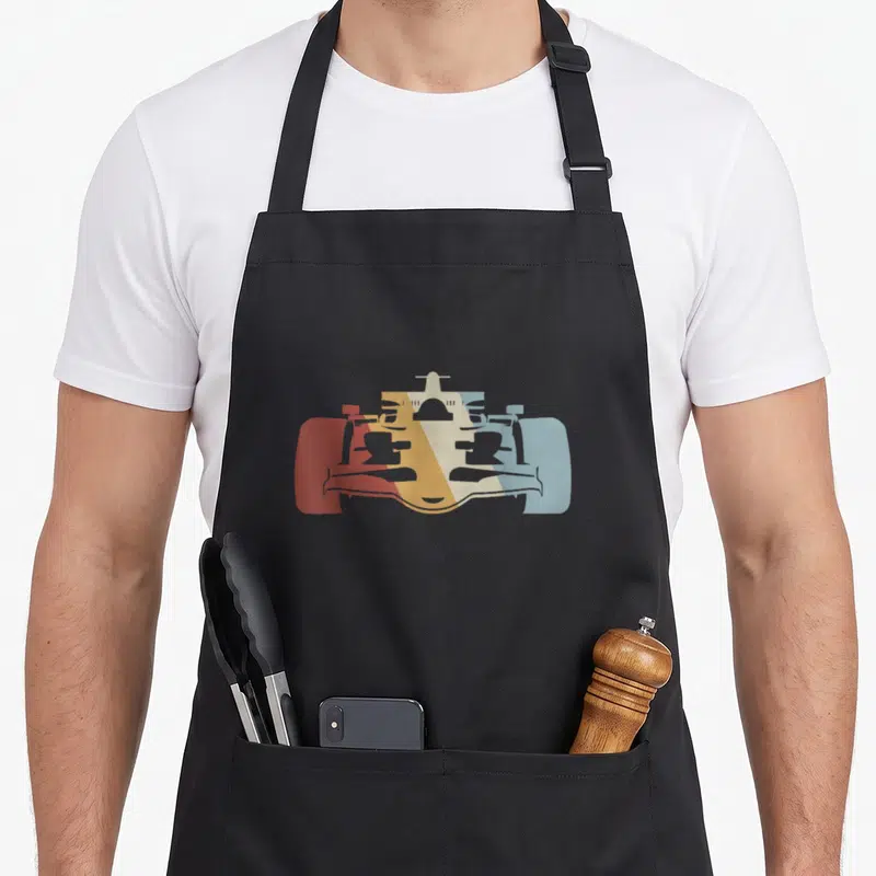 Vintage race car apron - Minimalist race car silhouette in red orange yellow cream and light blue blocks — shown on a black cotton canvas apron against a white background