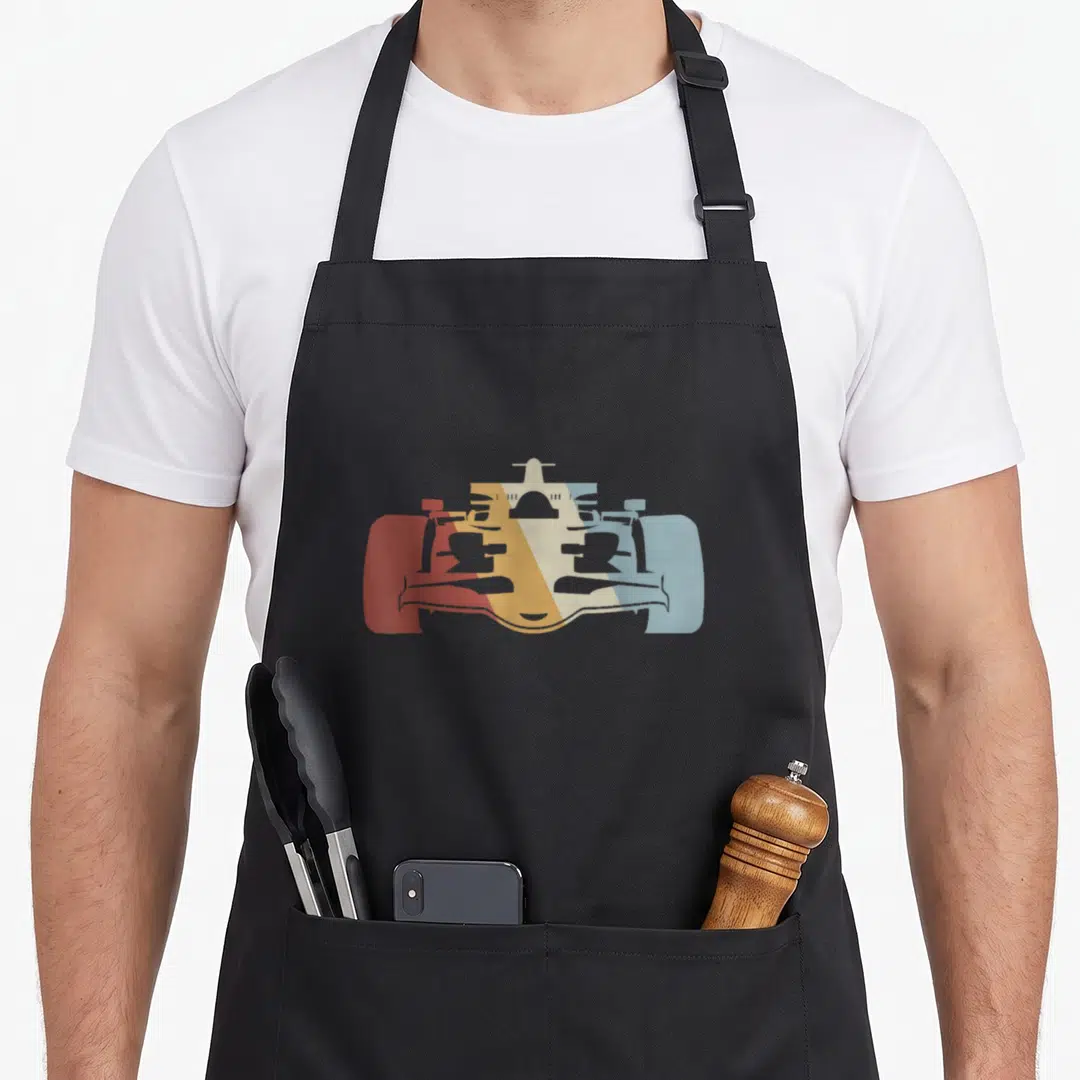 Vintage race car apron - Minimalist race car silhouette in red orange yellow cream and light blue blocks — shown on a black cotton canvas apron against a white background