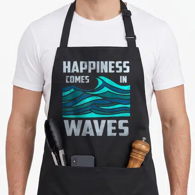 Happiness surfer apron - Retro teal and blue waves with HAPPINESS COMES IN WAVES text — shown on a black cotton canvas apron against a white background