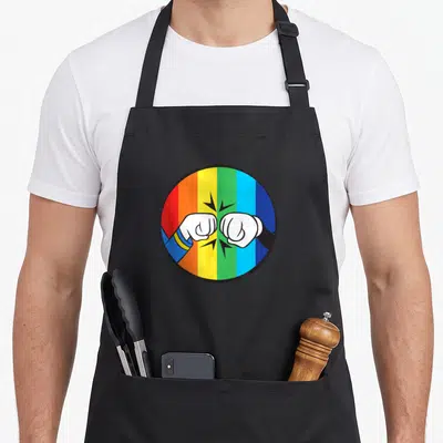 Fist rainbow apron - Two white cartoon fists bumping over vertical rainbow stripes in a circle — shown on a black cotton canvas apron against a white background