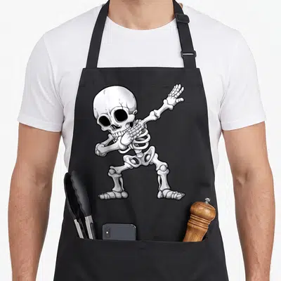 Rib halloween apron - Cartoon skeleton in white and grey performing the dab dance pose with black outlines — shown on a black cotton canvas apron against a white background