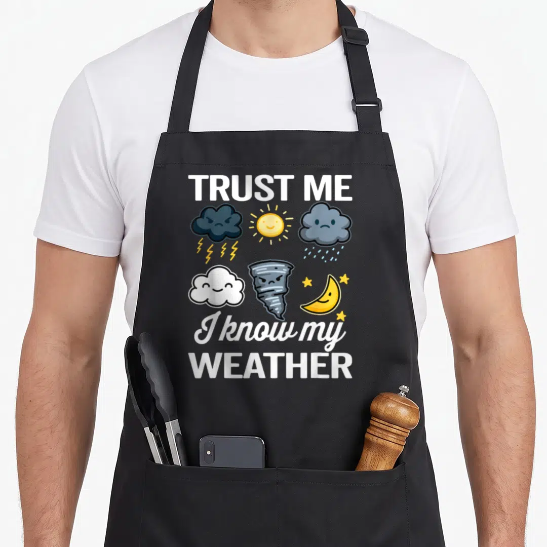 Weatherman meteorology meteorologist apron - Cartoon clouds sun tornado moon with text TRUST ME I know my WEATHER — shown on a black cotton canvas apron against a white background