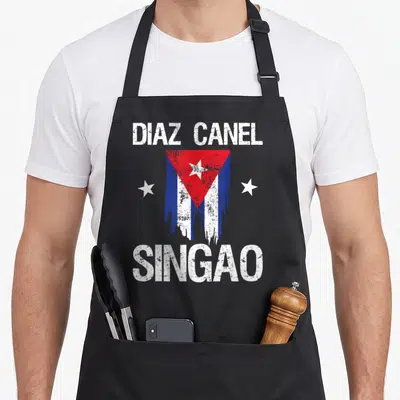 Diaz cuban boy apron - Distressed Cuban flag with two white stars and white text reading DIAZ CANEL SINGAO — shown on a black cotton canvas apron against a white background