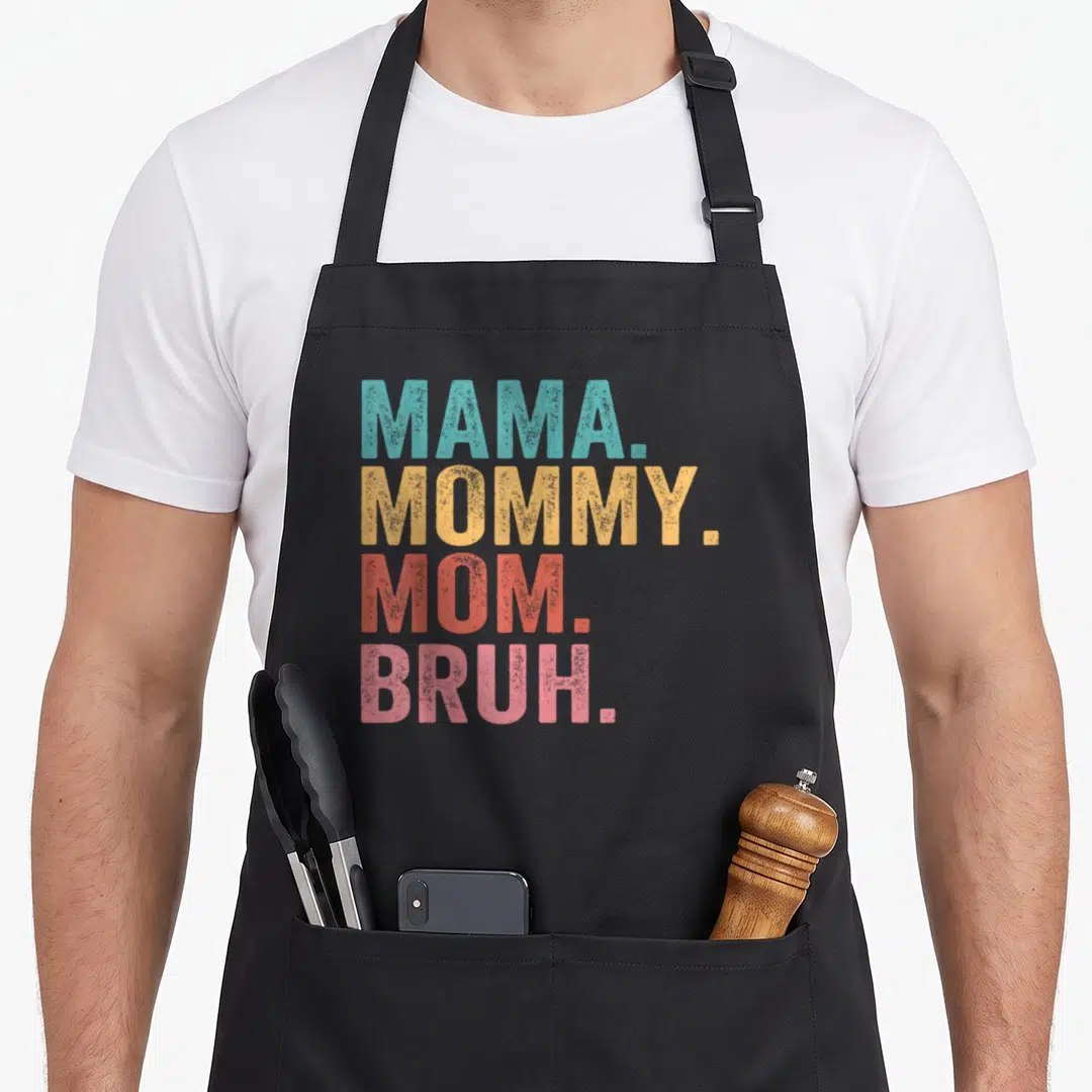 Bruh mother's day aprons - Stacked text MAMA MOMMY MOM BRUH in teal yellow red and pink vintage font — shown on a black cotton canvas apron against a white background