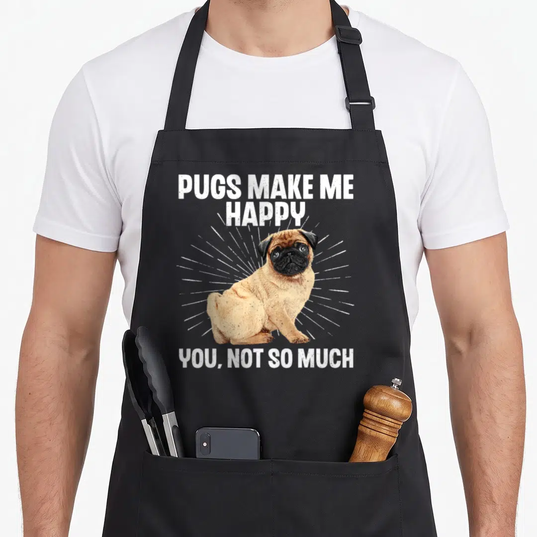 Puppy top dog aprons - Realistic tan pug sitting with white sunburst lines and text PUGS MAKE ME HAPPY YOU NOT SO MUCH — shown on a black cotton canvas apron against a white background