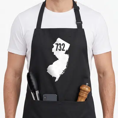 Jersey outline of an apron - White map of New Jersey shape with grey number 732 on front — shown on a black cotton canvas apron against a white background