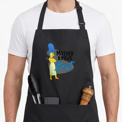 Marge mother's apron - Marge Simpson holding whisk next to stacked Mother Knows Best text in black and blue script — shown on a black cotton canvas apron against a white background