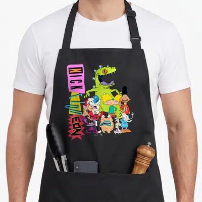 Throwback character aprons - Vertical NICKELODEON logo beside a cluster of various cartoon characters in green, pink — shown on a black cotton canvas apron against a white background