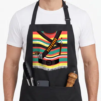Pistolero mexican apron - Black bandolier with gun and knife over red yellow green black white stripes cartoon — shown on a black cotton canvas apron against a white background
