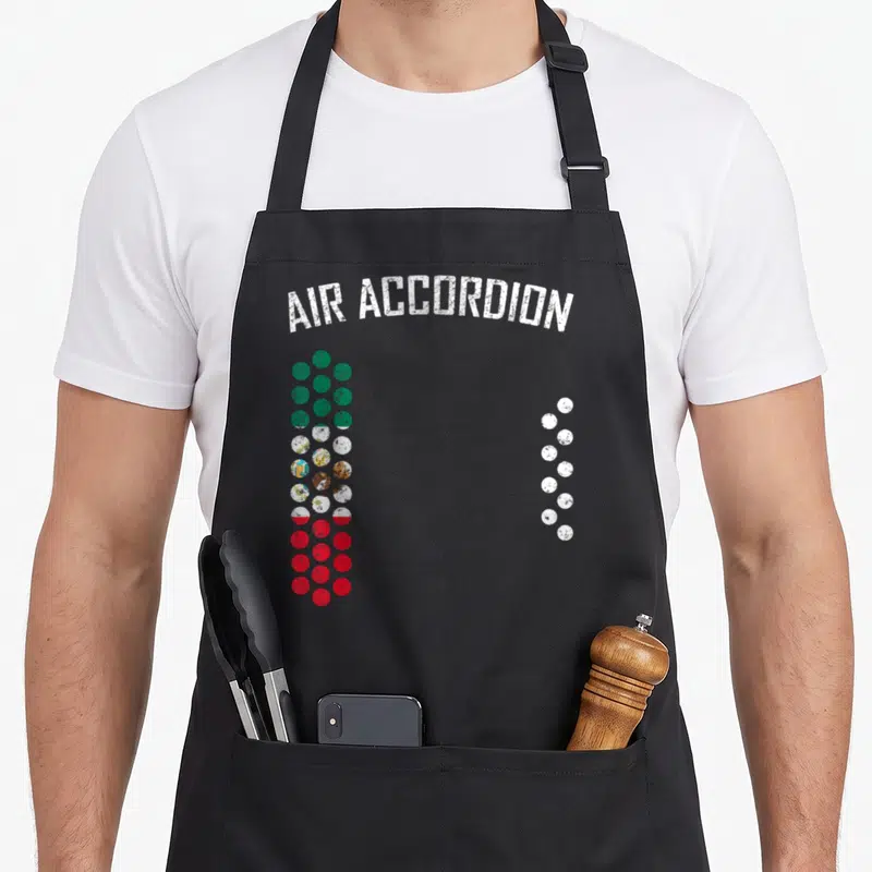 Air mexico apron - Arched text above green red and white dots forming accordion shape — shown on a black cotton canvas apron against a white background