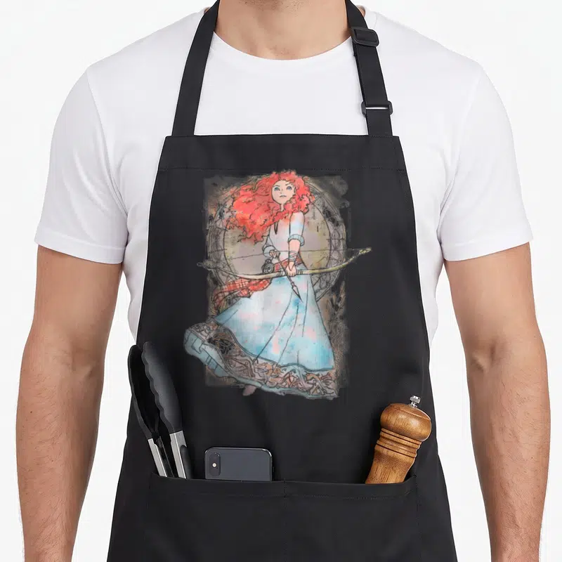 Brave merida apron - Watercolor woman with red hair holding a bow inside a decorative circular frame — shown on a black cotton canvas apron against a white background
