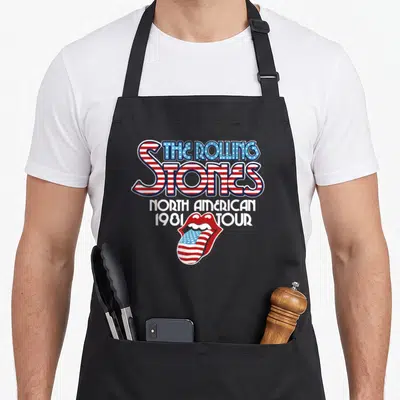 Vintage tour rolling stones apron - Red white and blue flag patterned letters reading The Rolling Stones North American — shown on a black cotton canvas apron against a white background