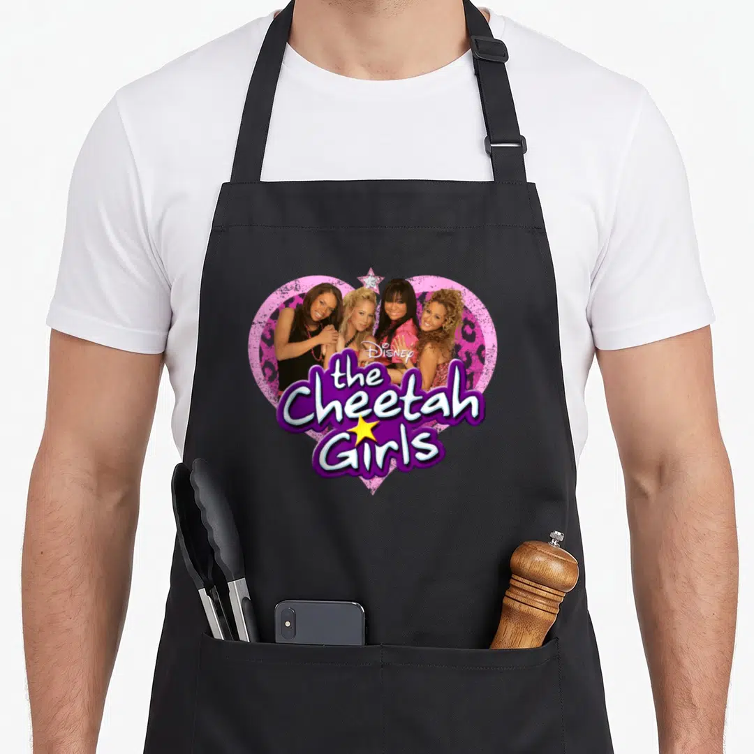 Channel cheetah apron - Four women inside a pink leopard heart with purple text and yellow star — shown on a black cotton canvas apron against a white background