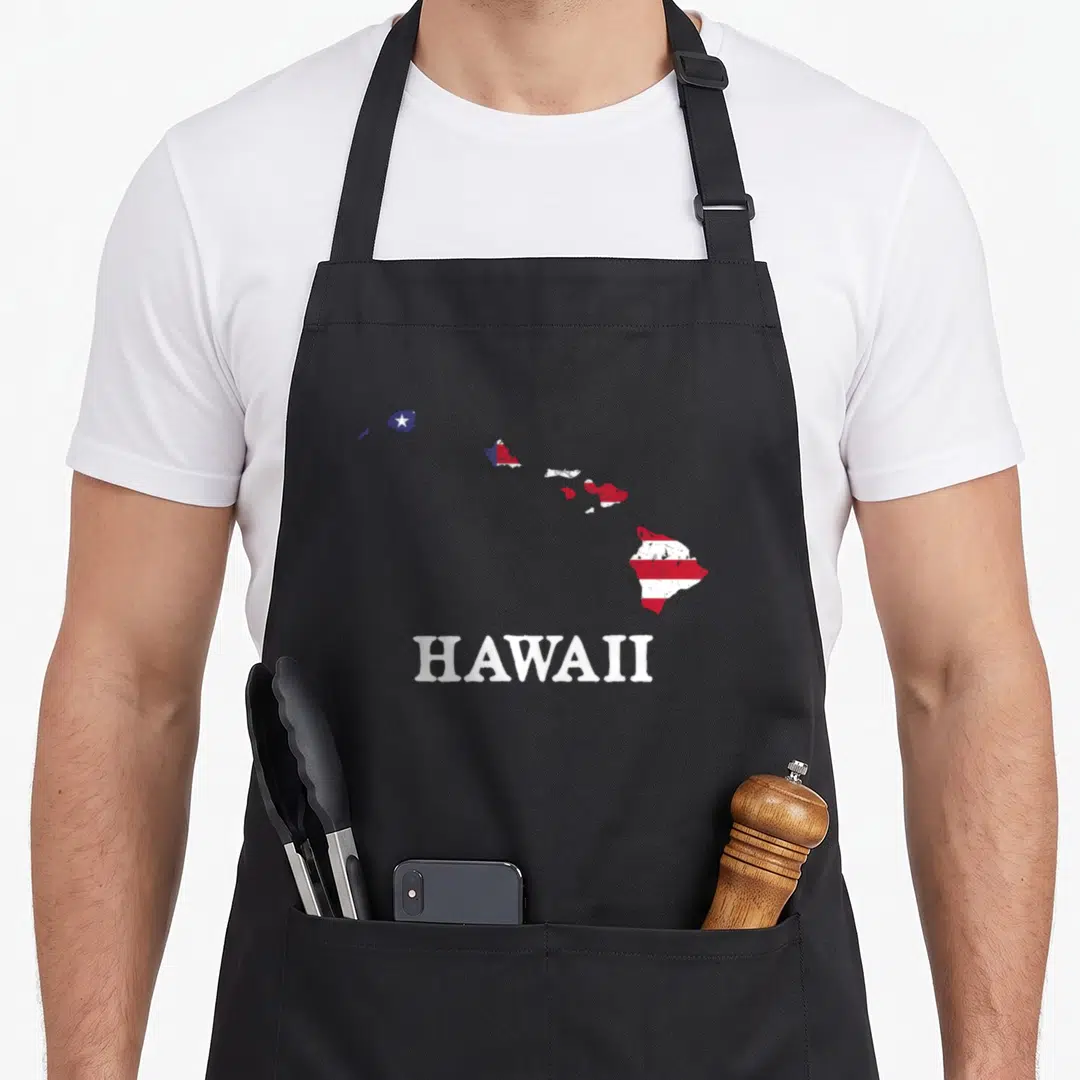 Hawaii 4th of july apron - Map of Hawaii islands filled with red white blue flag pattern above bold text — shown on a black cotton canvas apron against a white background