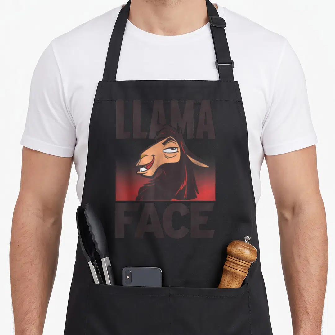 Emperor face apron - Cartoon llama head between LLAMA and FACE text over red gradient — shown on a black cotton canvas apron against a white background