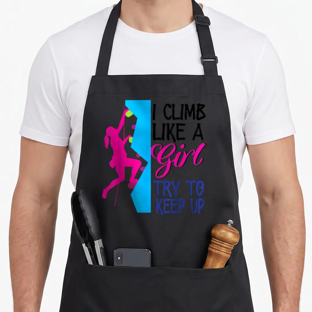 Rock climber bouldering apron - Pink climber silhouette on blue wall next to I Climb Like A Girl text — shown on a black cotton canvas apron against a white background