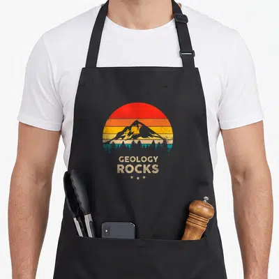 Geology meteorite collecting apron - Retro mountain sunset with GEOLOGY ROCKS text and three stars in red orange — shown on a black cotton canvas apron against a white background