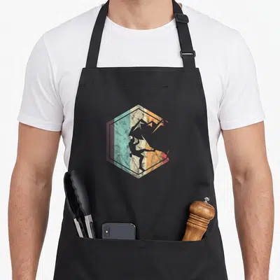 Mountaineering bouldering apron - Retro silhouette of a rock climber inside a vertical striped hexagon with teal — shown on a black cotton canvas apron against a white background
