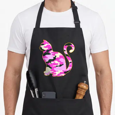 Kitten pink camo apron - Sitting cat silhouette filled with pink and green camo pattern outlined in orange — shown on a black cotton canvas apron against a white background