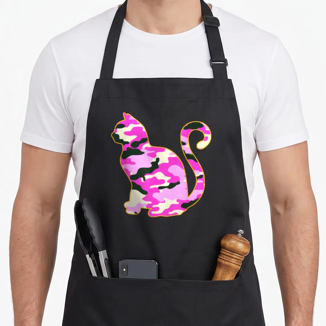 Kitten pink camo apron - Sitting cat silhouette filled with pink and green camo pattern outlined in orange — shown on a black cotton canvas apron against a white background