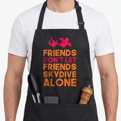 Skydiver friends apron - Two pink skydiver silhouettes above orange and pink text reading FRIENDS DON'T LET FRIENDS — shown on a black cotton canvas apron against a white background