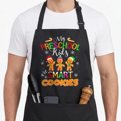 Preschool women's christmas aprons - Three gingerbread men with Santa hats below stacked My Preschool Kids Are Smart — shown on a black cotton canvas apron against a white background