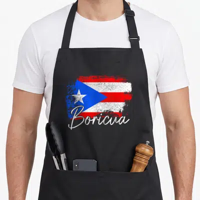Rico pride apron - Distressed Puerto Rican flag with white Boricua script overlay in red, white, and blue — shown on a black cotton canvas apron against a white background