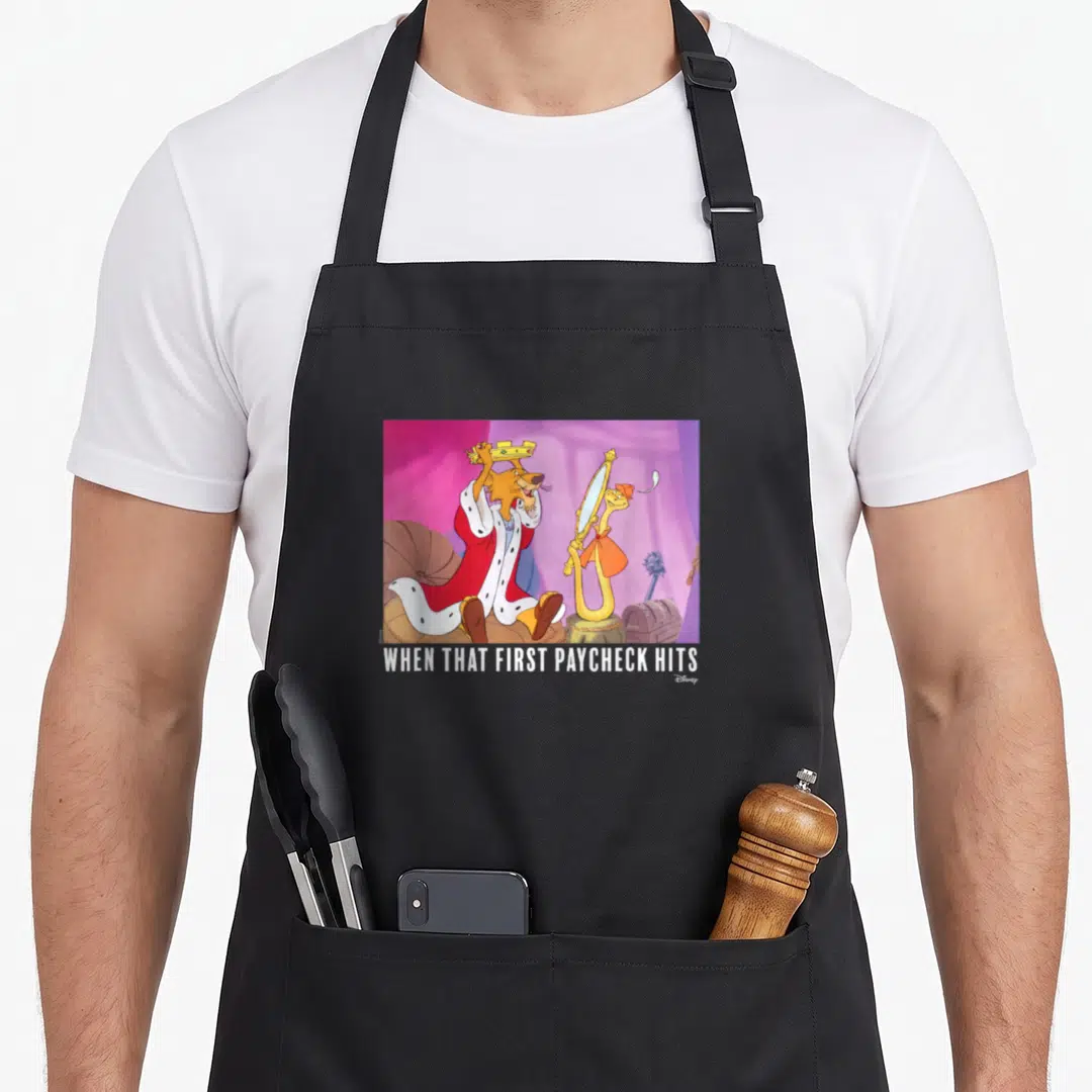 Paycheck robin hood apron - Cartoon lion in red robe holding crown next to snake with mirror under white text — shown on a black cotton canvas apron against a white background