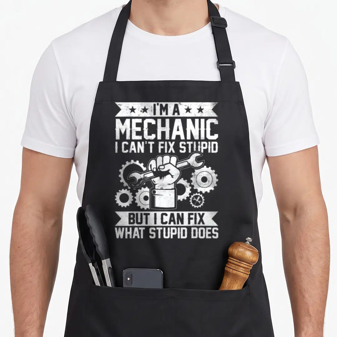 Engineer auto mechanic apron - White distressed hand holding wrench surrounded by gears with stacked banner text — shown on a black cotton canvas apron against a white background