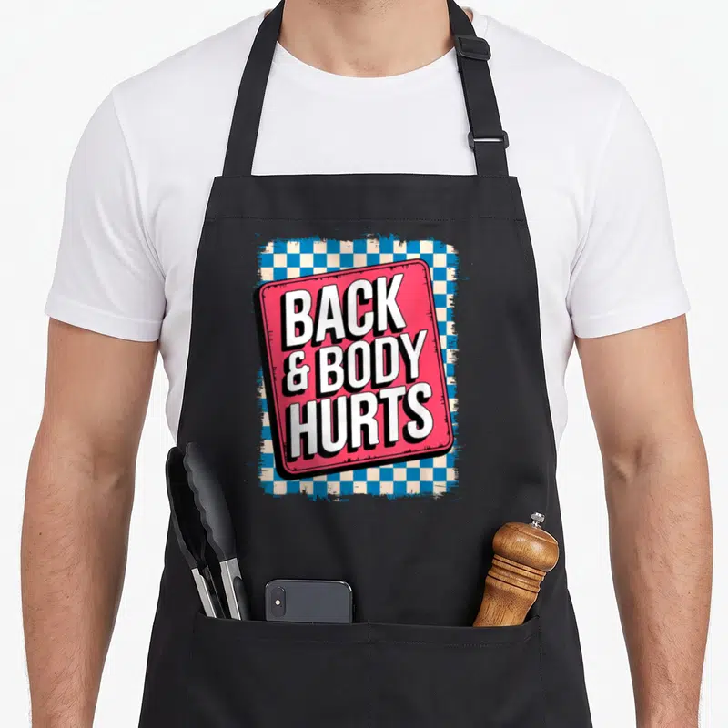 Bodybuilder body apron - Tilted red sign reading BACK & BODY HURTS over blue and white checkerboard — shown on a black cotton canvas apron against a white background