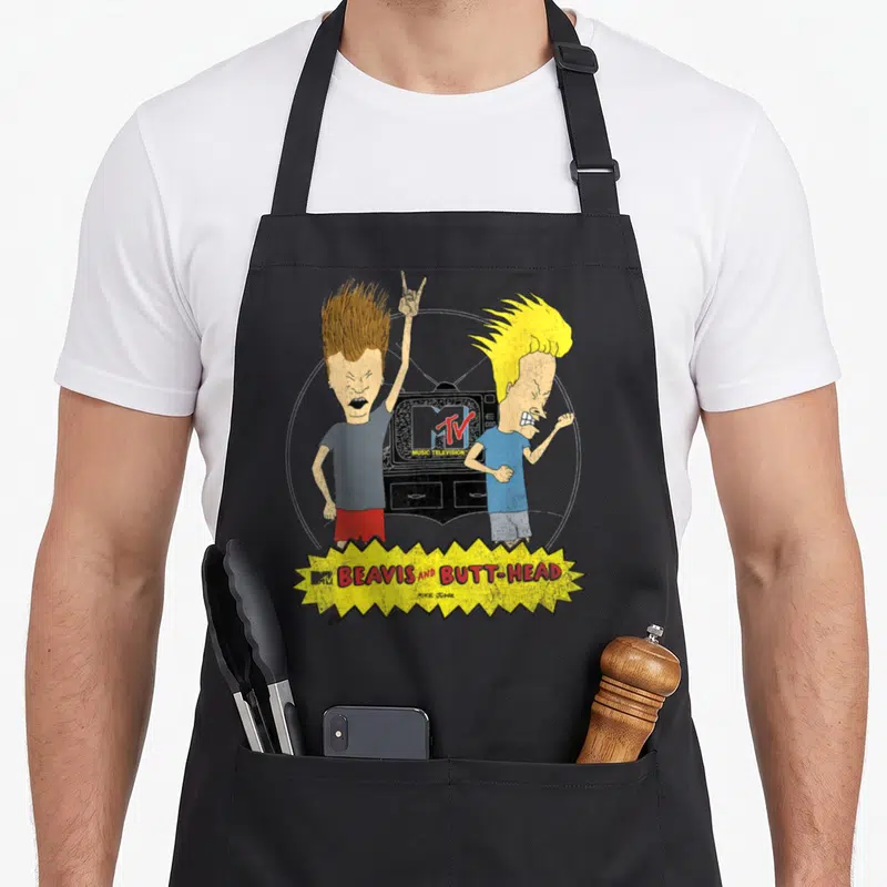 Mtv beaverton apron - Beavis and Butt-Head cartoon characters with TV and yellow burst logo — shown on a black cotton canvas apron against a white background
