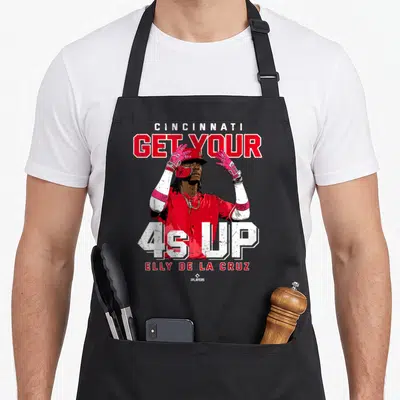 Elly las cruces apron - Baseball player graphic with CINCINNATI GET YOUR 4s UP ELLY DE LA CRUZ text in red white pink — shown on a black cotton canvas apron against a white background