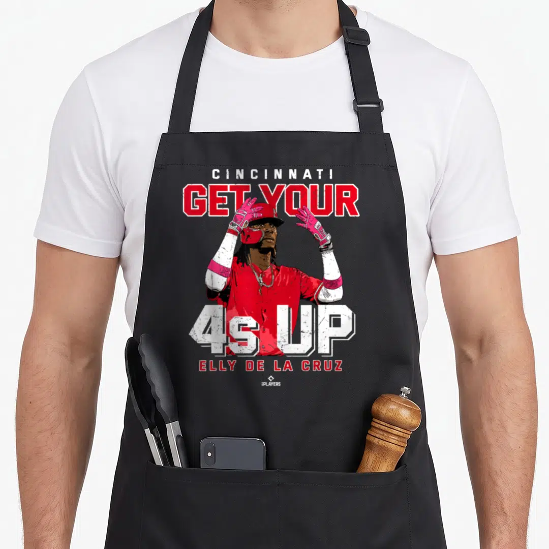Elly las cruces apron - Baseball player graphic with CINCINNATI GET YOUR 4s UP ELLY DE LA CRUZ text in red white pink — shown on a black cotton canvas apron against a white background