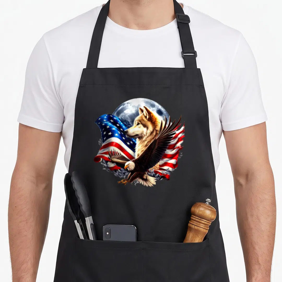 Moon american flag apron - Realistic wolf head, bald eagle, and waving US flag against a full moon — shown on a black cotton canvas apron against a white background