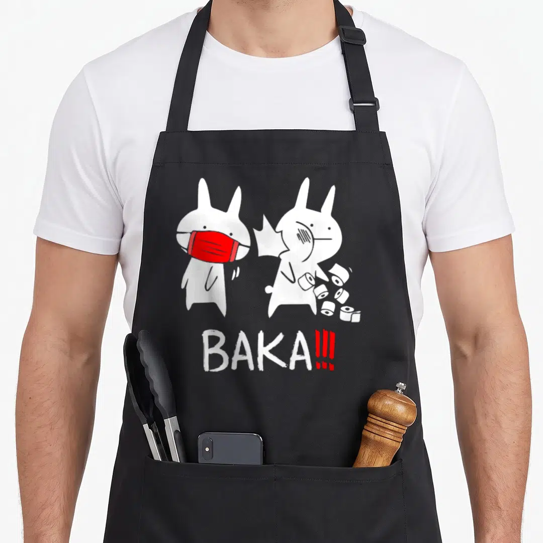Baka anime apron - Two white rabbits, one with red mask, one with toilet paper, BAKA text — shown on a black cotton canvas apron against a white background