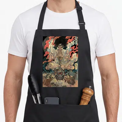 Japanese artwork apron - Deity Akidomaru crushing snake with red fire, blue clouds, and Japanese text boxes in beige — shown on a black cotton canvas apron against a white background