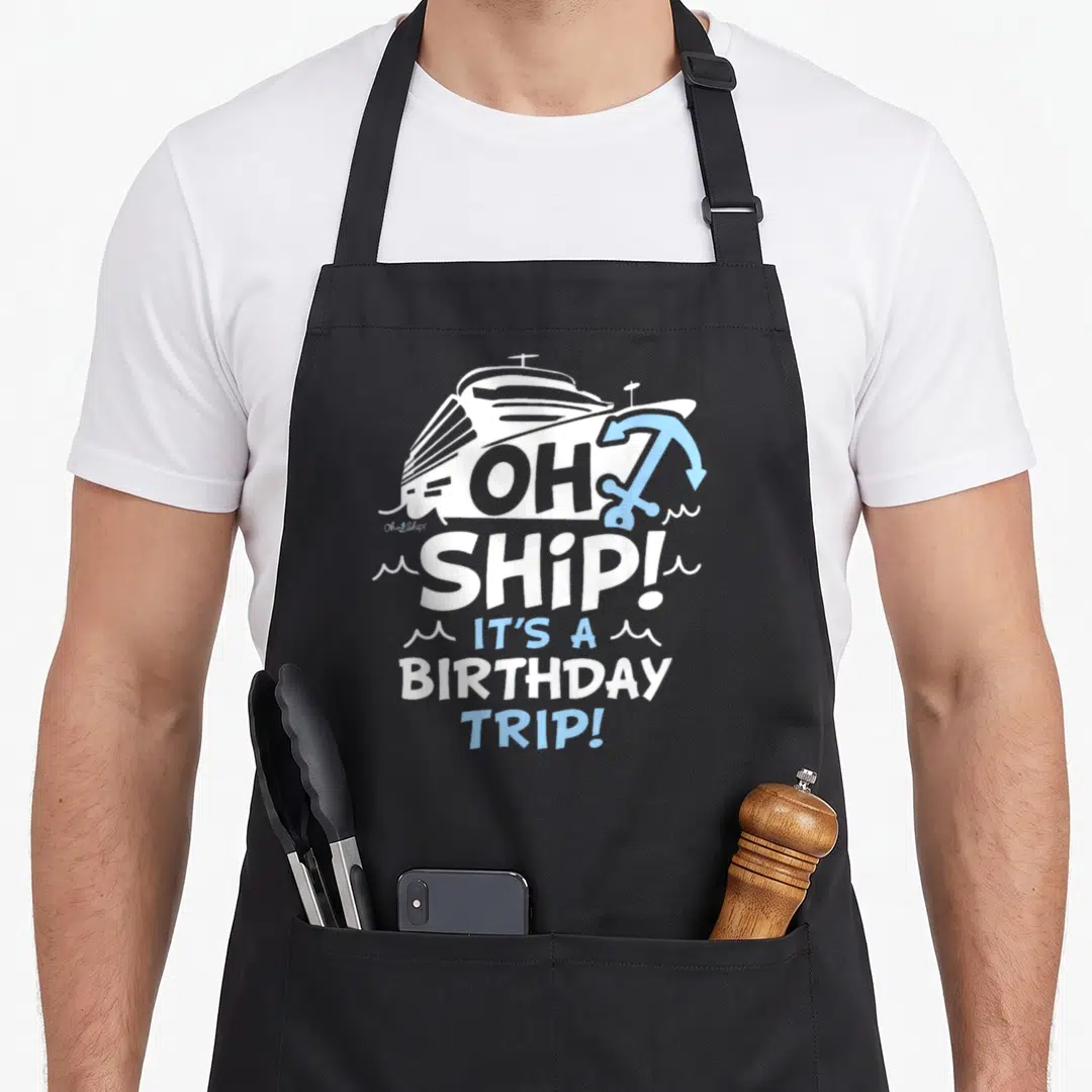 Ship trip birthday apron - White cruise ship and blue anchor graphic with stacked typography reading Oh Ship — shown on a black cotton canvas apron against a white background