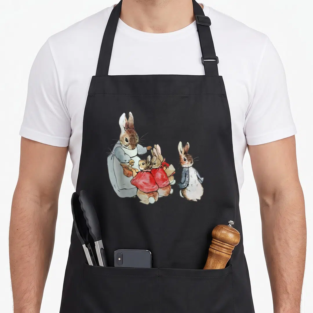 Cottagecore easter bunny aprons - Watercolor large rabbit holding basket facing three smaller rabbits in red and blue — shown on a black cotton canvas apron against a white background