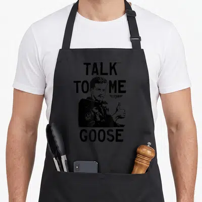 Illustration goose apron - Distressed black man giving thumbs up with Talk To Me Goose text — shown on a black cotton canvas apron against a white background