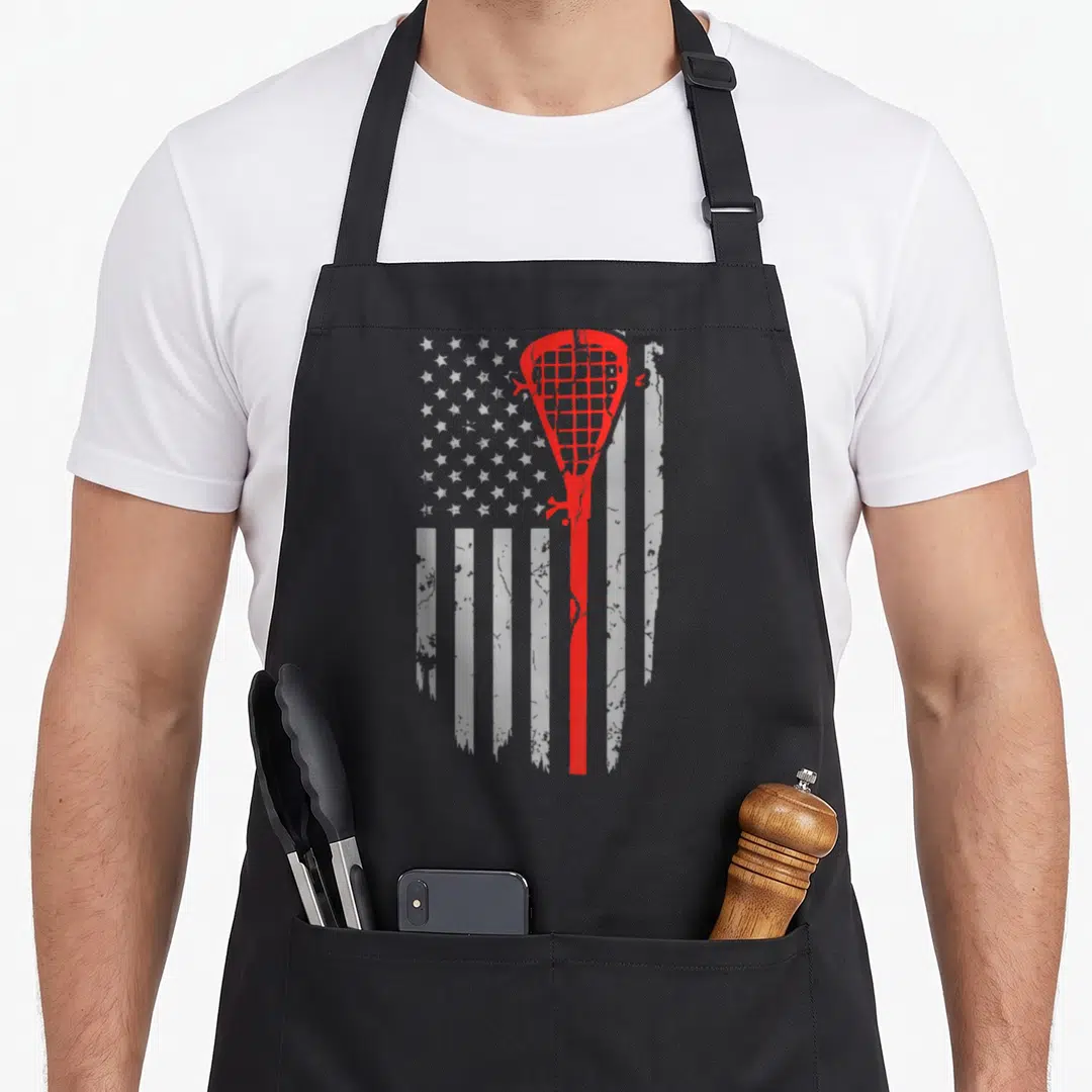 Youth american flag apron - Red lacrosse stick silhouette over distressed white stars and stripes pattern — shown on a black cotton canvas apron against a white background
