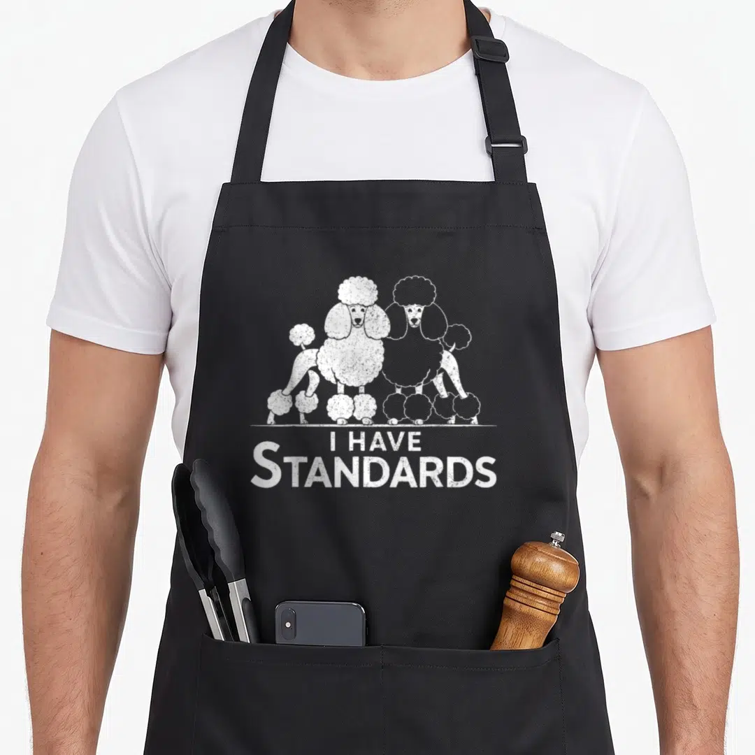 Cool poodle standard size of apron - Two white poodles standing over I Have Standards text with distressed texture — shown on a black cotton canvas apron against a white background
