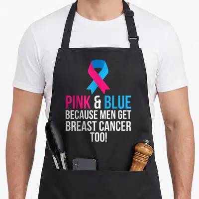 Blue breast cancer awareness aprons - Pink and blue awareness ribbon above four lines of text reading Because Men Get — shown on a black cotton canvas apron against a white background