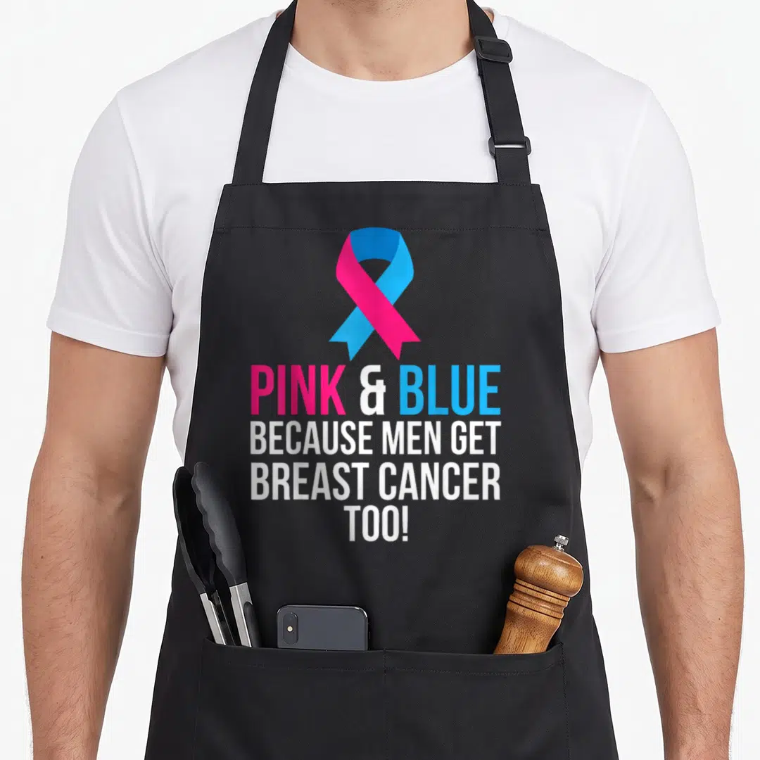 Blue breast cancer awareness aprons - Pink and blue awareness ribbon above four lines of text reading Because Men Get — shown on a black cotton canvas apron against a white background