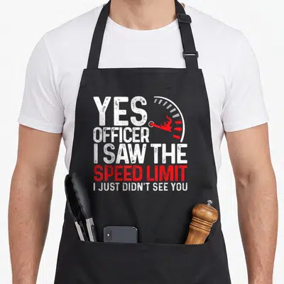 Officer funny novelty collection apron - Distressed white and red text reading Yes Officer I Saw The Speed Limit next — shown on a black cotton canvas apron against a white background