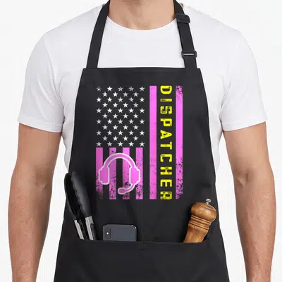 Dispatcher thin line apron - Pink US flag with white stars, pink headset, vertical yellow DISPATCHED text, distressed — shown on a black cotton canvas apron against a white background