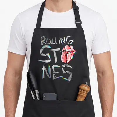 Glass rolling stones apron - Shattered glass ROLLING STONES text with integrated red lips logo in white and colored — shown on a black cotton canvas apron against a white background